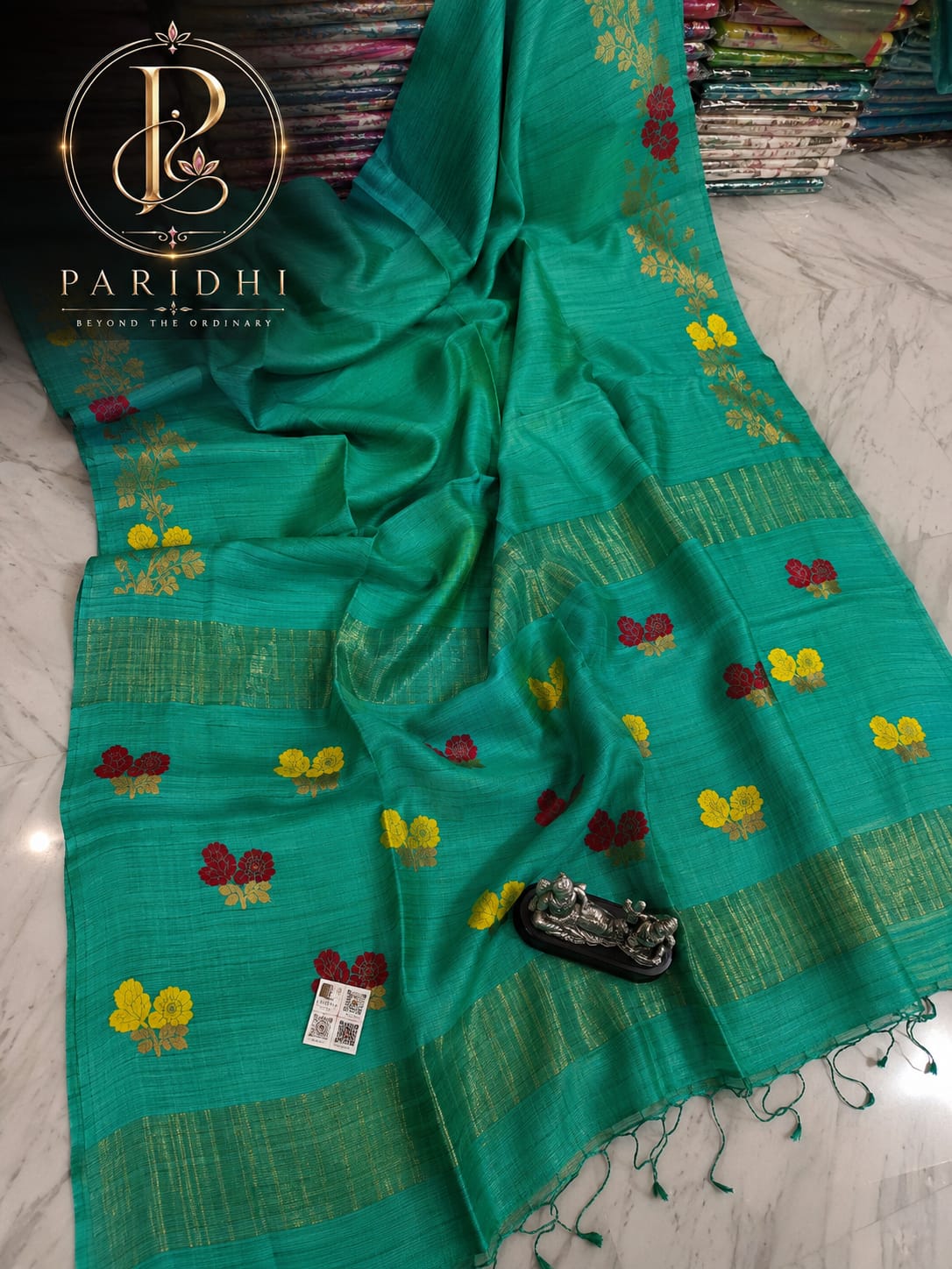 Teal green Motka Benarasi saree with floral resham buta and gold zari bands