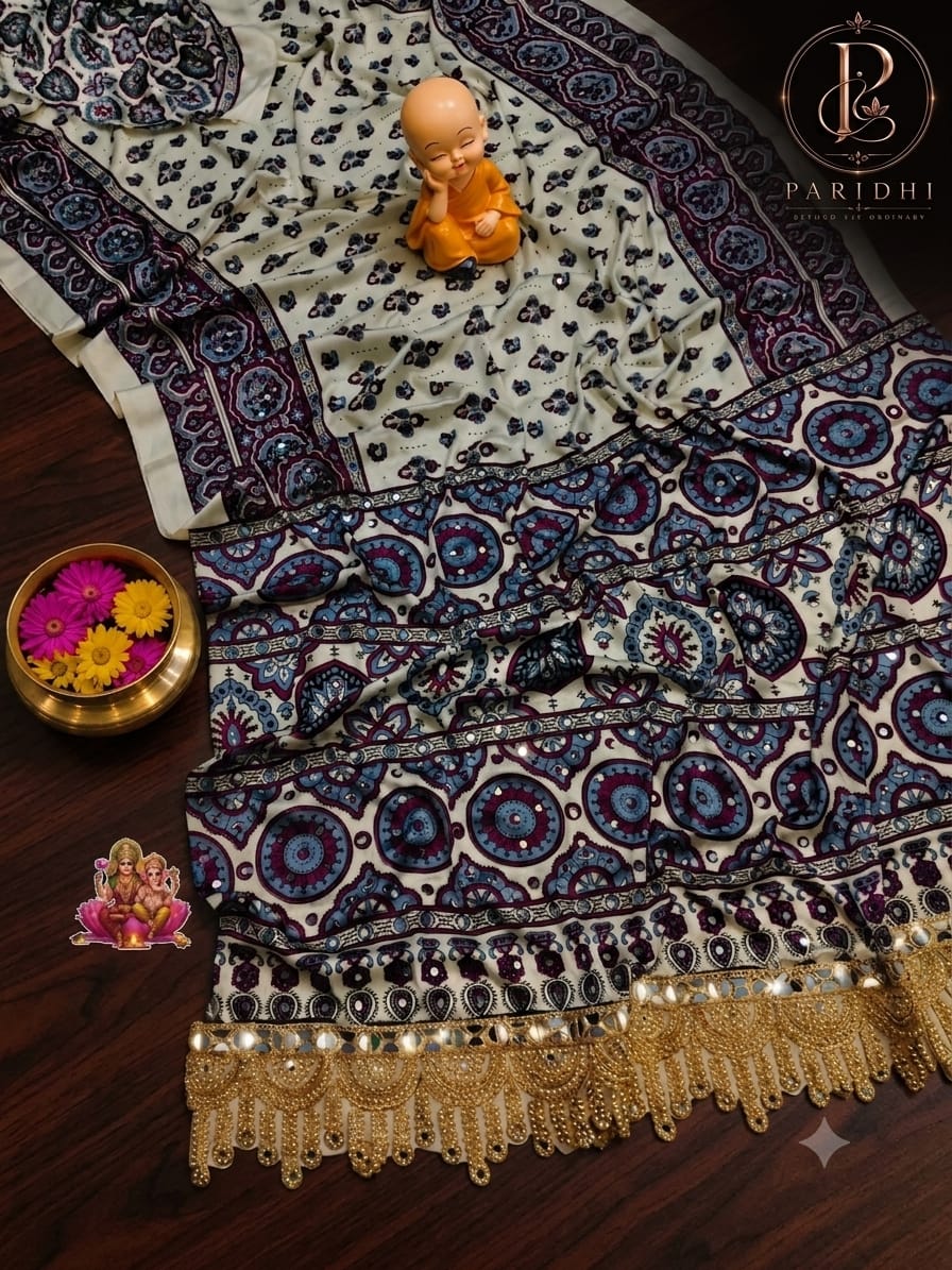 Ivory modal silk saree with wine and indigo ajrakh print, mirror work and gold beaded lace pallu