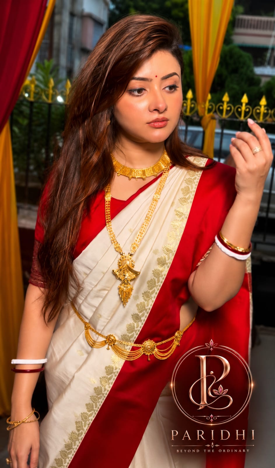 Woman draped in the white and red Garad saree with gold jewellery